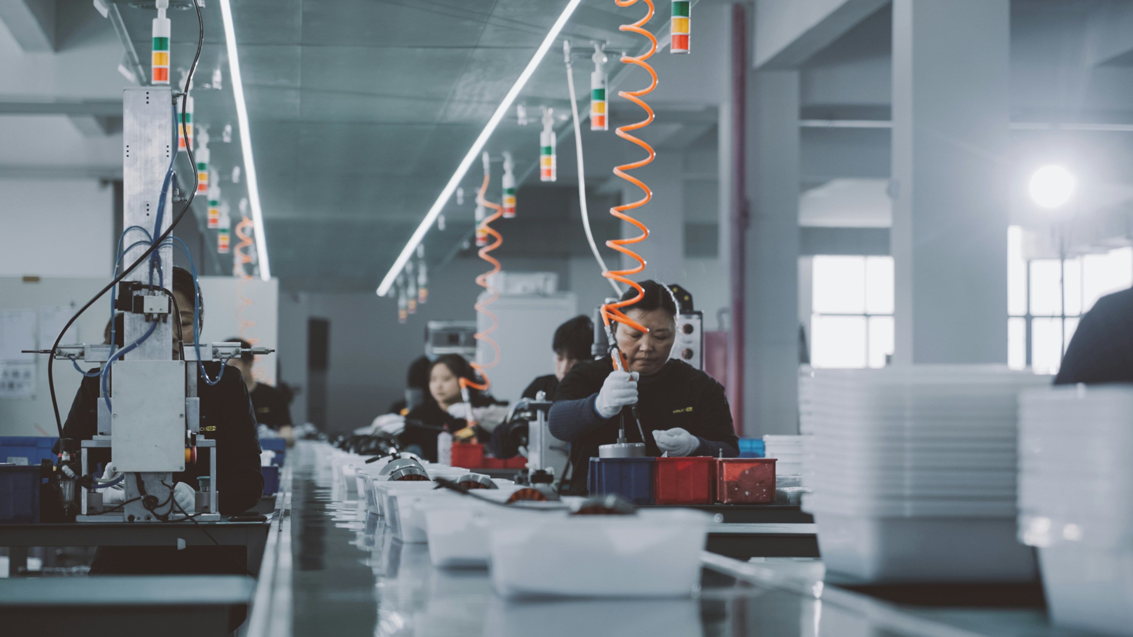 Workers assembling products on a factory production line — the manufacturing strength behind every brand